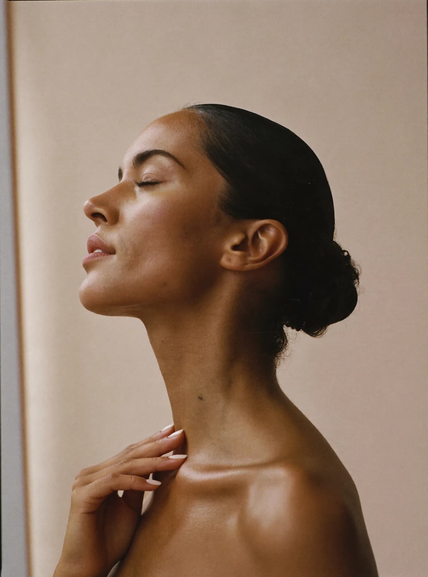 Mujer de perfil con piel luminosa, luz natural suave